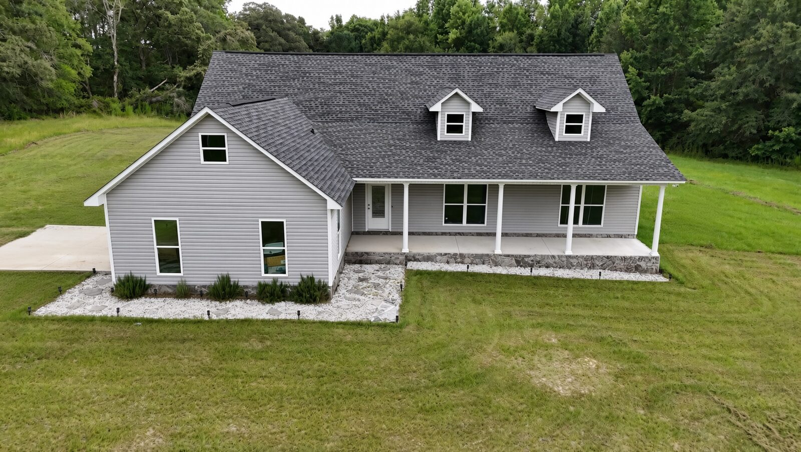 Modern gray farmhouse with rock bed